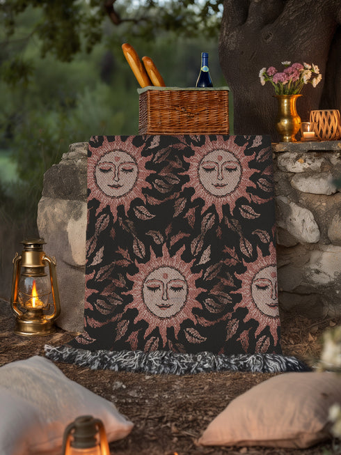 Luxurious woven cotton throw featuring dreamy blush pink sun faces with closed eyes against black background with delicate ray patterns and elegant fringe trim. Perfect celestial wall hanging, witchy bedroom decor, or dark academia throw blanket.